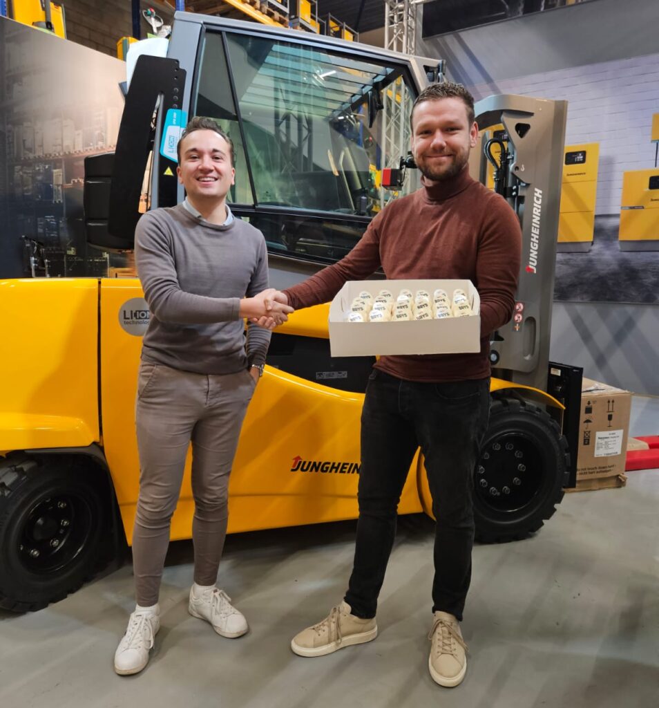 2 mannen geven elkaar de hand bij het overhandigen van brys gebakjes.